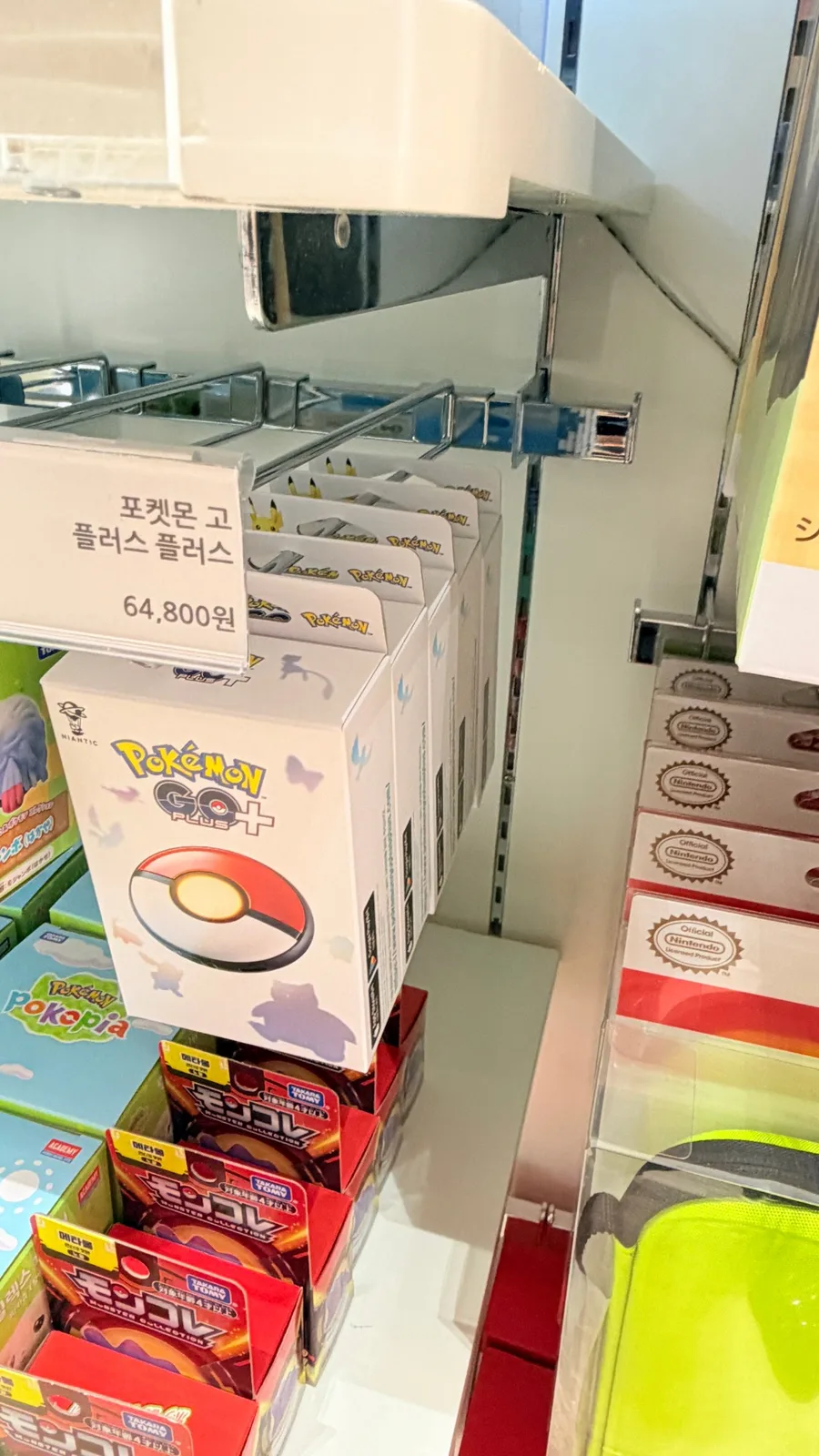Pokémon GO Plus+ units on the shelf at Daewon Shop Hyundai Premium Outlets Songdo, with a price tag showing ₩64,800